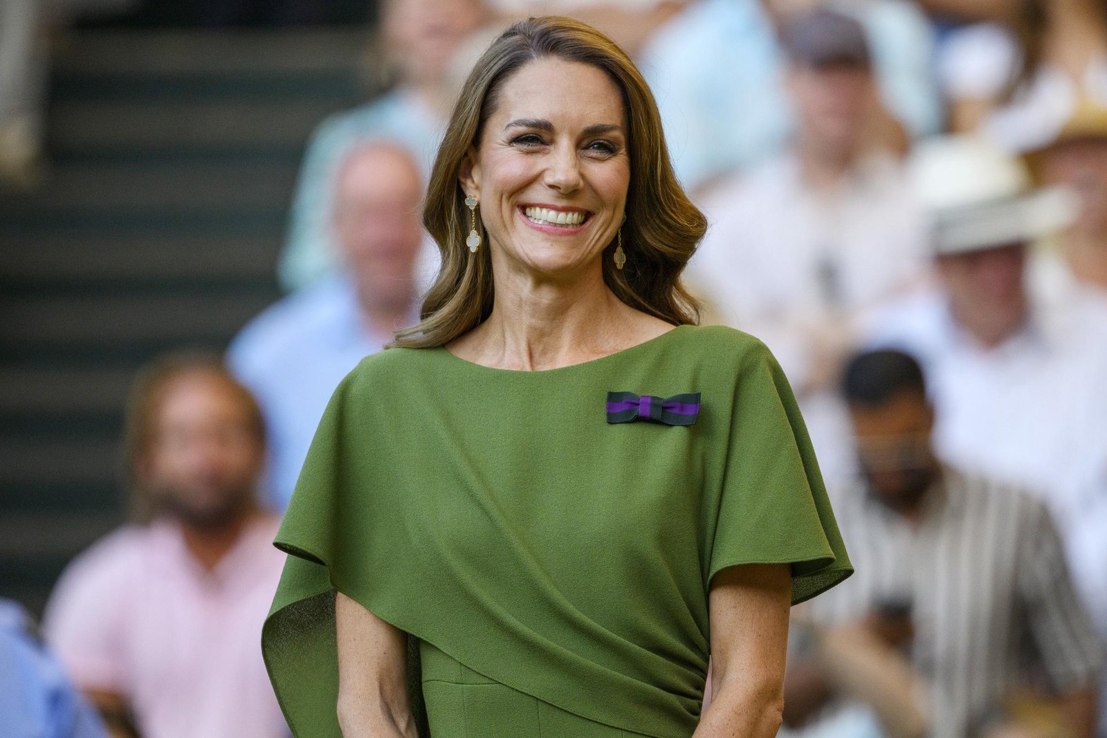 A closer look at Catherine's final Wimbledon outfit shows the custom olive-green Emilia Wickstead dress she chose for the men's singles final. She completed the look with soft waves, drop earrings, and a warm smile as she prepared for the trophy presentation.