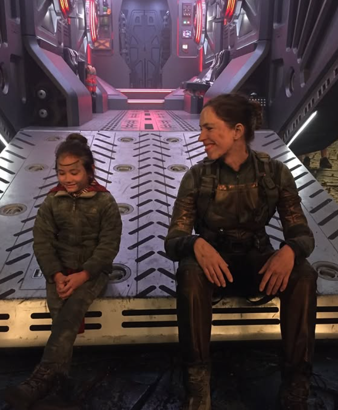 Kaylee Hottle and Rebecca Hall sit together on a set resembling a futuristic spacecraft during production of a "Godzilla" film. Rebecca shared a behind-the-scenes photo while remembering her young co-star after the co-star's death.