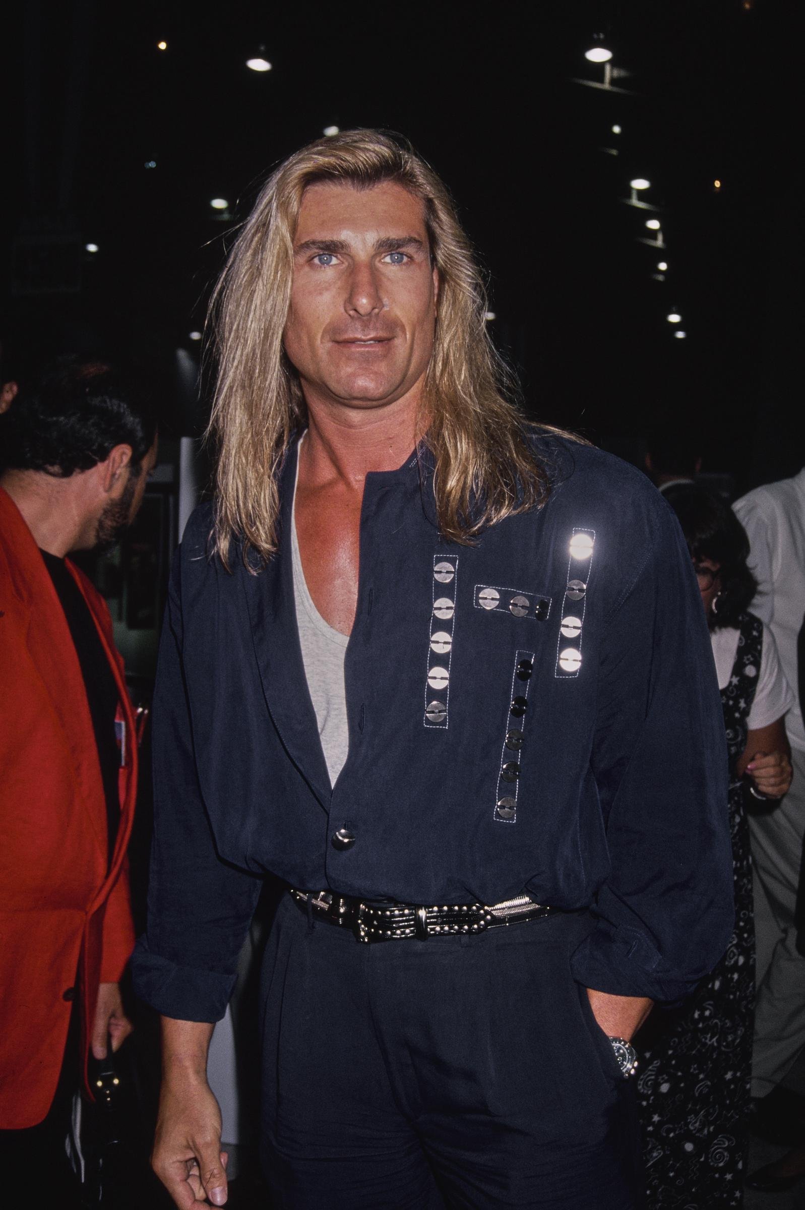He walked out of that meeting with a lucrative contract in hand. In this photo, the iconic romance book cover star attended the "Pauly Does Dallas" premiere after party at the Comedy Store in Los Angeles, California, on August 26, 1992.