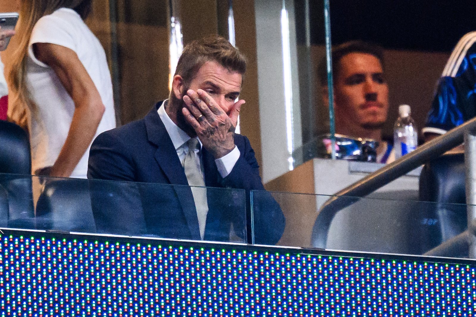 David Beckham is captured in a moment of stress or surprise, covering his mouth during a tense development of the historic final match at MetLife Stadium.