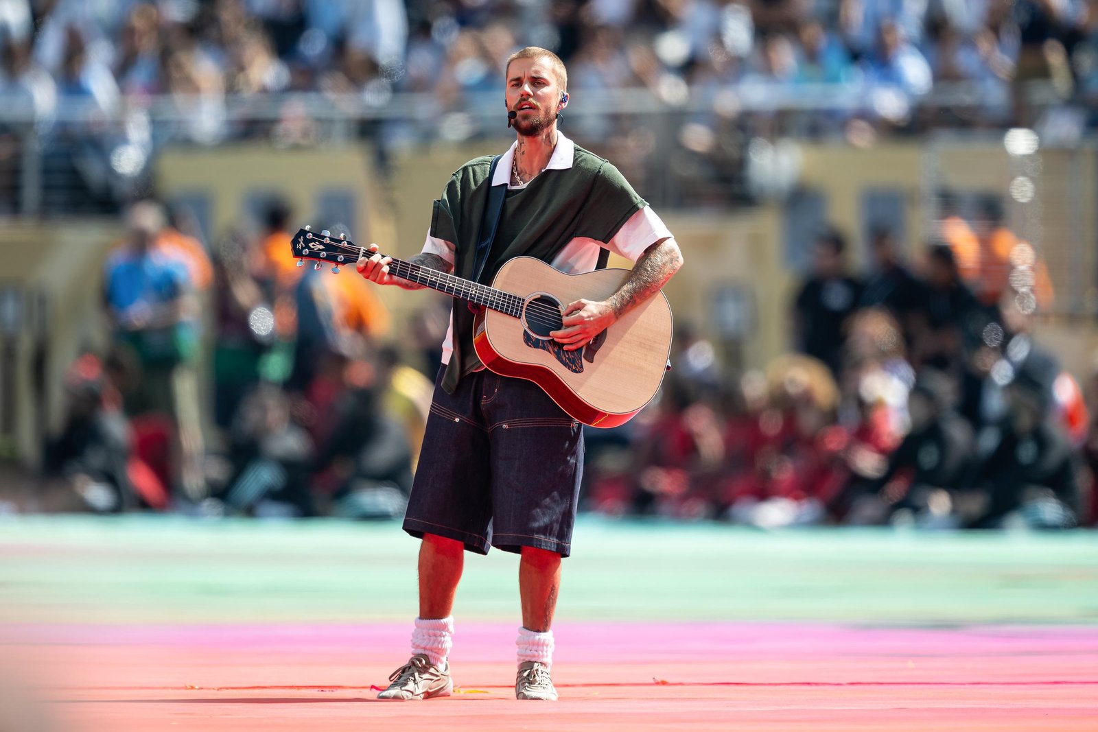 Justin Bieber performs his acoustic rendition of "Everything Hallelujah" at the World Cup Final, sporting the custom SKYLRK green deconstructed shirt and baggy denim shorts that fans quickly labeled a "homeless pancho fit."