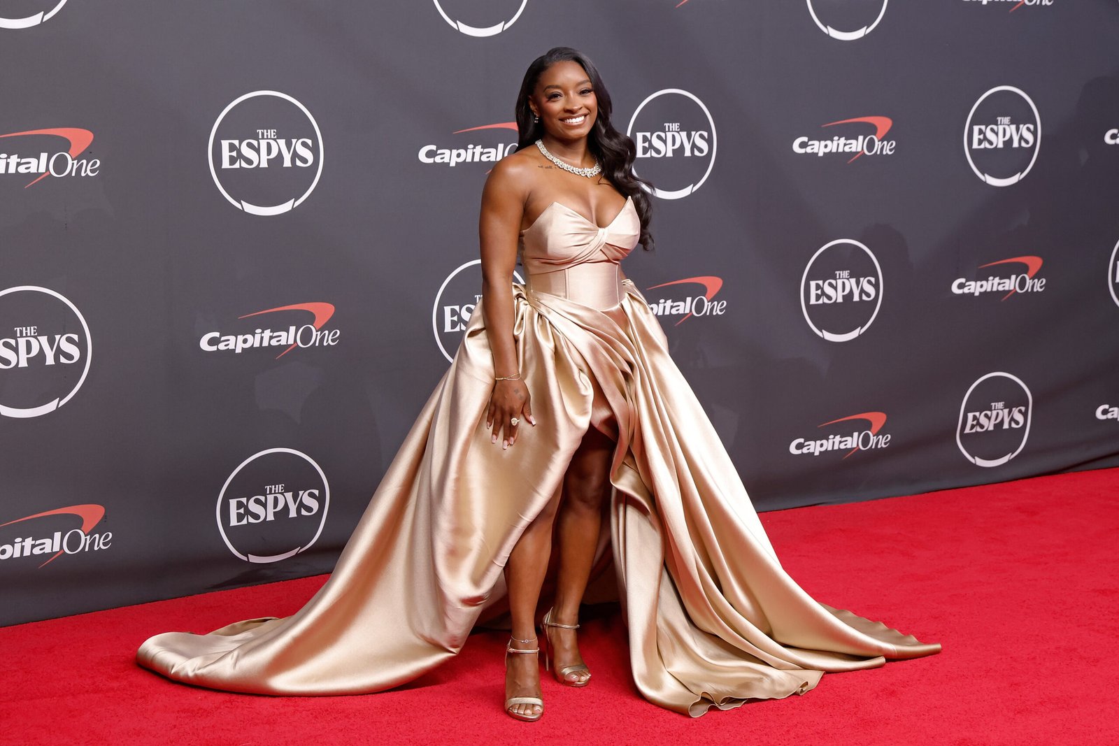 A closer look at Biles' ESPYS outfit shows the flowing silhouette and long train that made her one of the evening's most talked-about fashion figures. As reactions to the viral video remained divided, the red carpet photos kept the spotlight on her look.