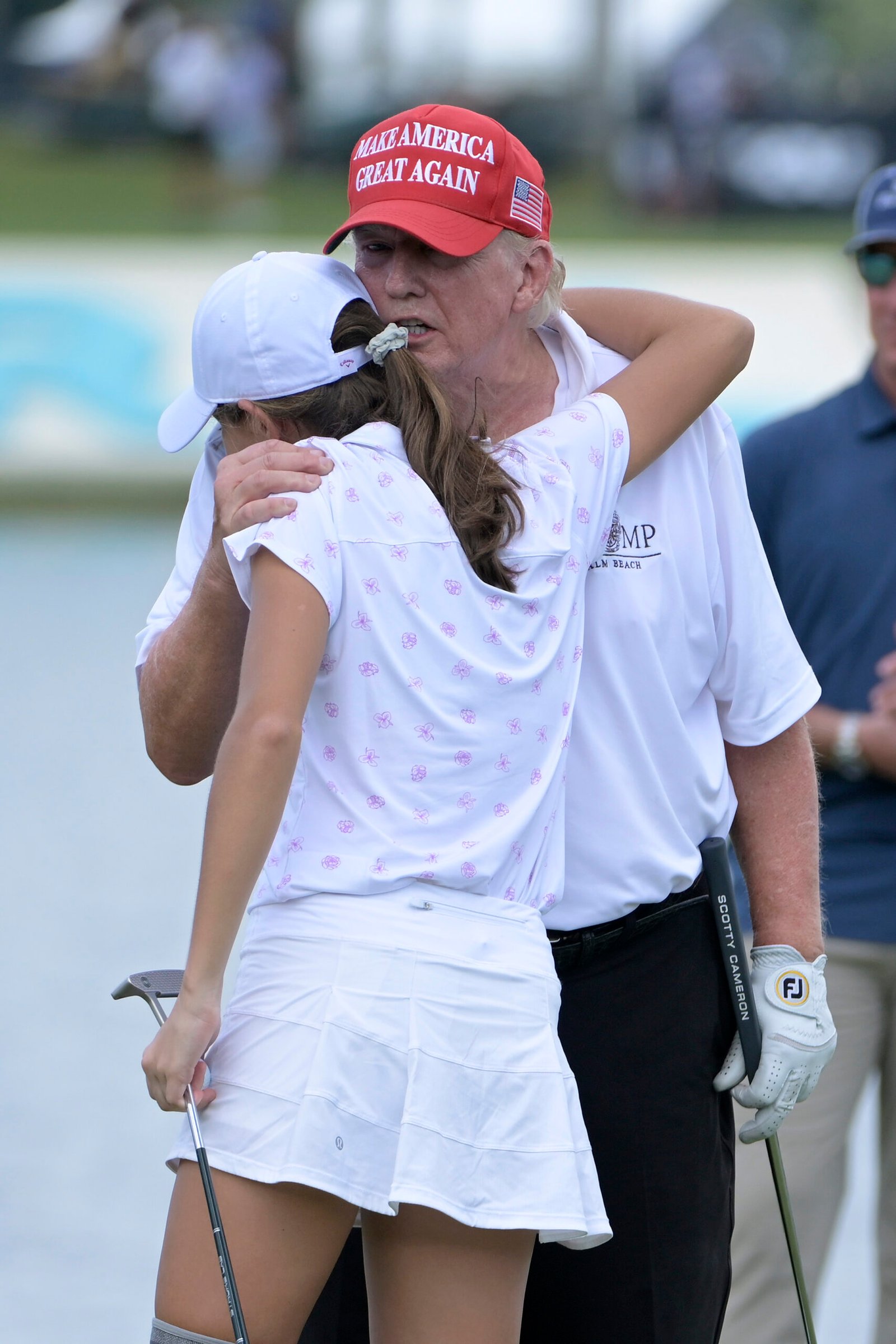 Donald Trump and granddaughter Kai Trump hug on the 18th green during a pro-am prior to the LIV Golf Invitational - Miami at Trump National Doral Miami on October 27, 2022 in Doral, Florida